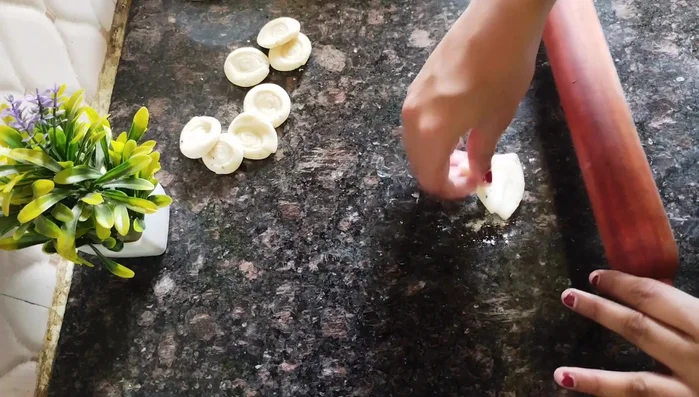 Lightly press the triangular shape, and use a fork to poke holes in the nimki to prevent puffing during frying.