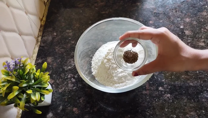 In a bowl, add refined flour, celery, nigella seeds, salt, and oil. Mix well by rubbing the oil into the flour until it resembles breadcrumbs.
