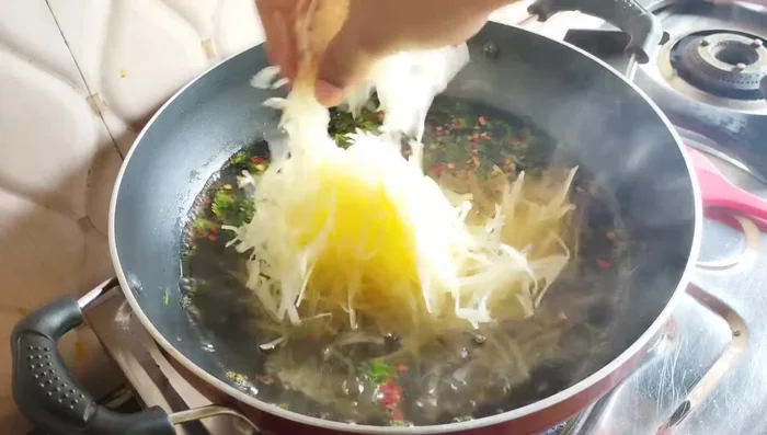 Add the squeezed, well-drained grated potatoes to the boiling mixture.
