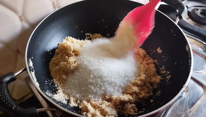 Add sugar and stir. Add water (or milk) and stir until the mixture thickens and semolina grains separate. Increase heat and continue stirring until completely dry.