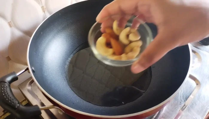 Heat ghee (or oil) in a pan. Lightly fry almonds and cashews until lightly browned. Remove immediately.