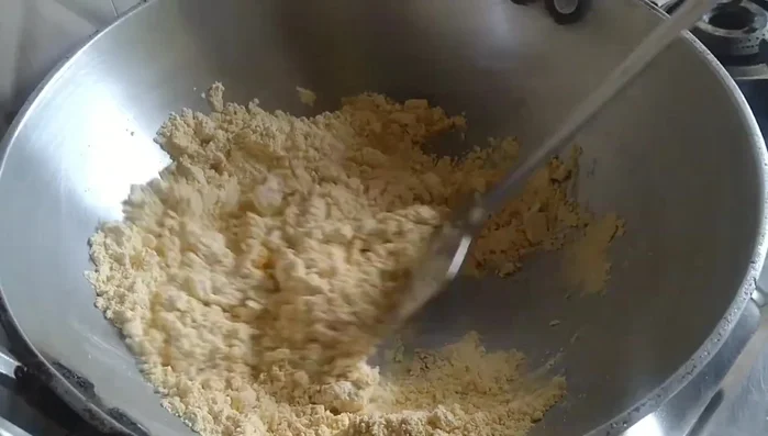 Add the sieved gram flour to the ghee and sugar mixture. Fry on very low flame, stirring constantly.