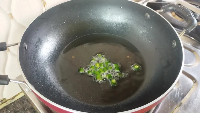 Fry Chilies: Add 4-5 finely chopped green chilies and fry until they crackle.