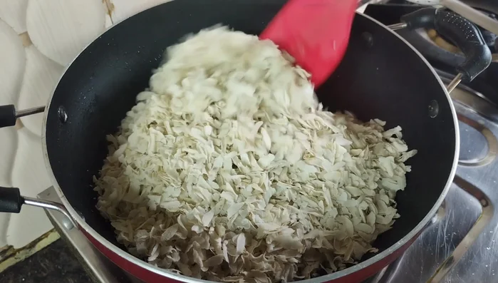 Combine and Season: Add the roasted Poha to the pan. Stir continuously on low flame until the turmeric coats evenly. Add salt, sugar powder, roasted peanuts and coconut. Mix well for 4-5 minutes.