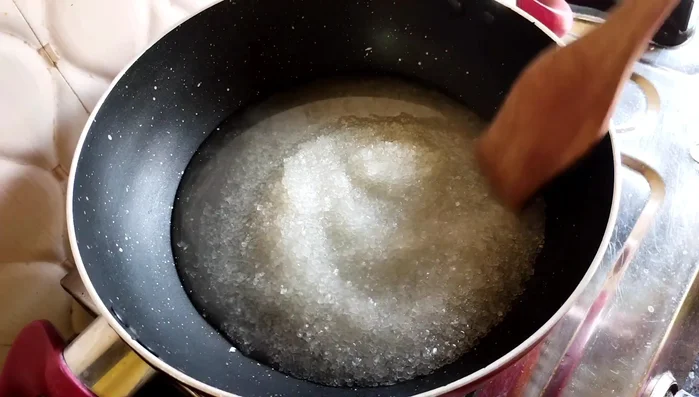In a saucepan, combine sugar and 1/4 cup of water. Cook over low heat until the sugar melts and forms a thick syrup (5-6 minutes).