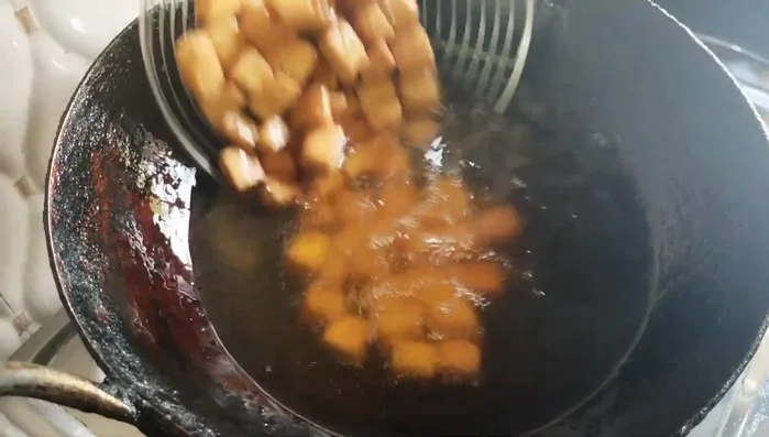 Remove the fried shakkarpara and place them on a plate to cool.