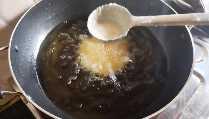 Once the Pua begins to rise, gently pour oil around it to help it puff up evenly. Do not touch it until fully puffed.