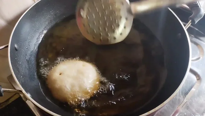 Once puffed, carefully flip the Pua and fry until golden brown on both sides. Fry over medium heat to ensure it cooks evenly and doesn't burn on the outside while staying raw inside.