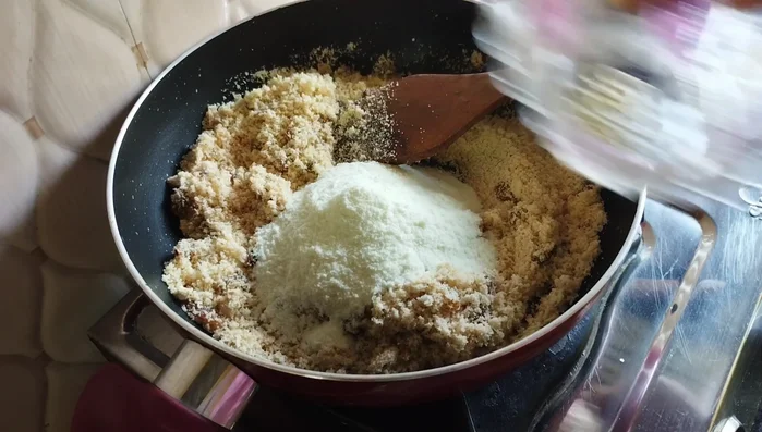 Stir in milk powder and crushed cardamom. Fry for 2-3 minutes.