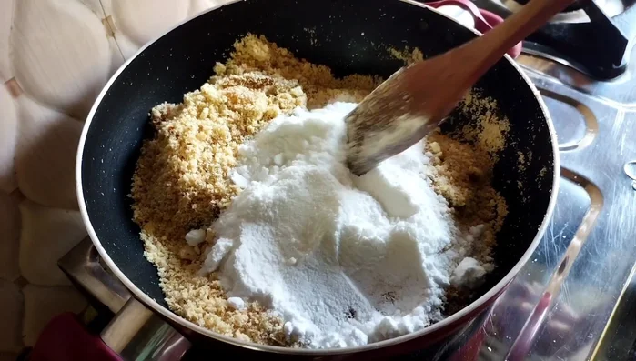 Add sugar powder and mix well. Add 1-2 tablespoons of water (or milk for immediate consumption) and fry until the mixture comes together.