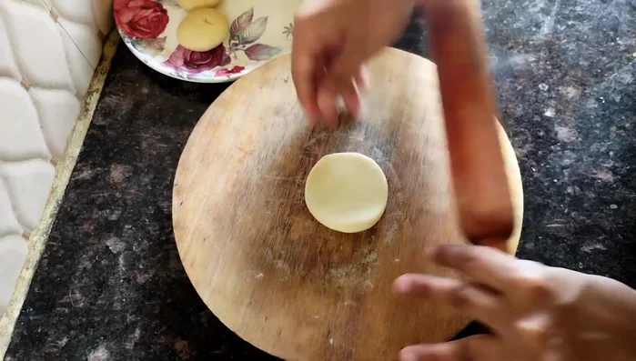 Roll out small portions of dough thinly (slightly thinner than puri).