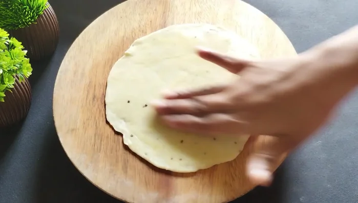 Stack four rotis, applying oil and dry flour between each layer to create layers.