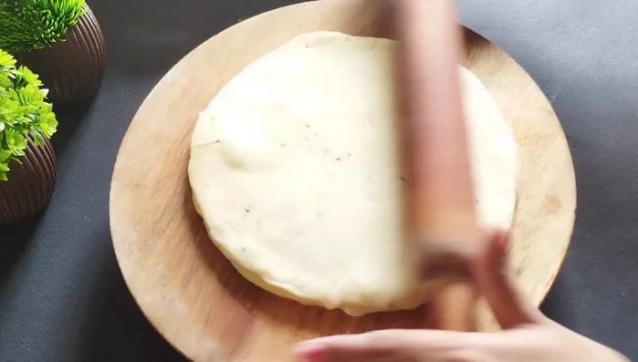 Roll out the stacked rotis into a large, thin circle.
