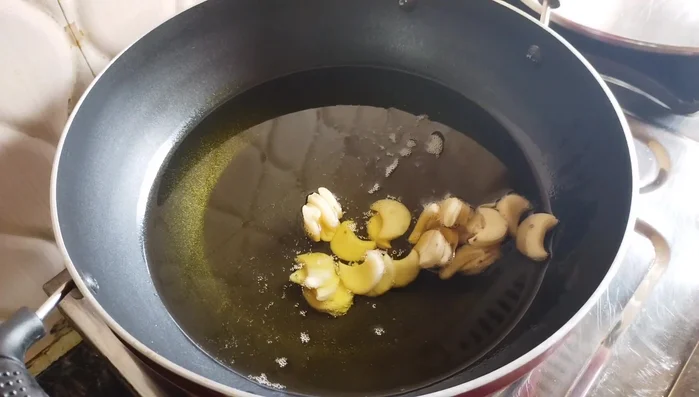 Heat oil in a pan. Fry the cashew namak pare on low heat until golden brown, flipping halfway through.