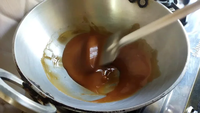 Cook the melted jaggery for 2-3 minutes until it forms a soft ball when tested in water.