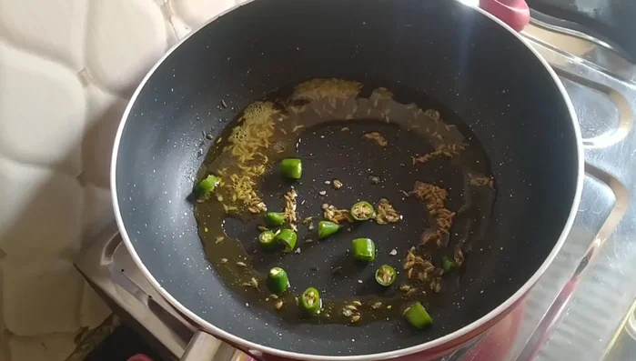 Add 2 finely chopped green chilies and sauté briefly.