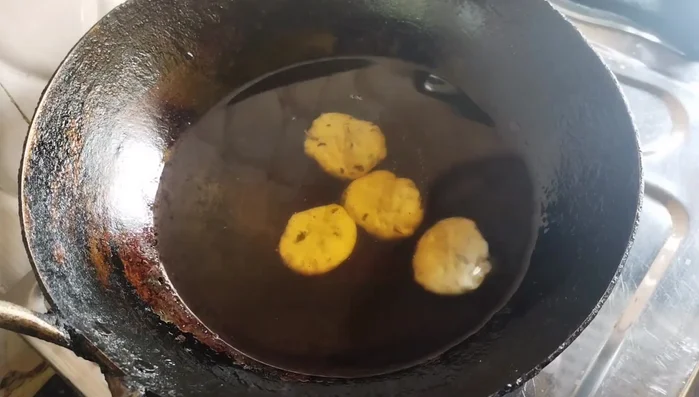 Carefully add the mathri to the oil, ensuring not to overcrowd the pan.