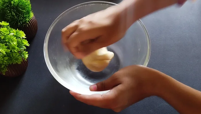Knead the rested dough and roll it into small, slightly elongated balls.