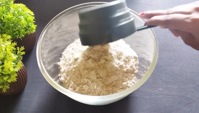 Take 2 cups of flour (all-purpose or refined) and mix in ½ cup semolina and ¼ cup grated dry coconut.