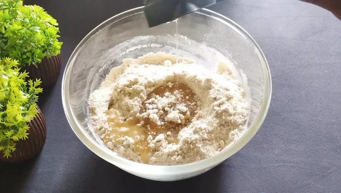 Add ¼ cup refined oil (or ghee) and mix roughly until it resembles breadcrumbs.