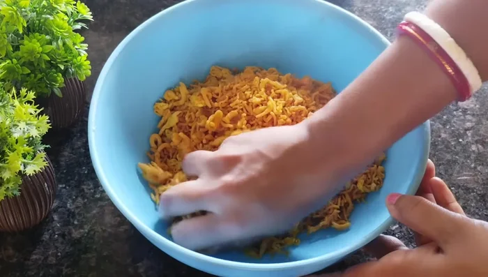 Break the fried sev into smaller pieces by hand.
