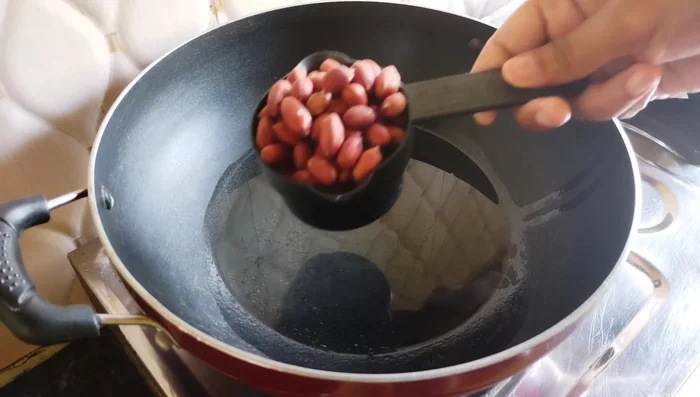 Heat the pan and add oil. Fry peanuts on low flame until they crackle and change color.