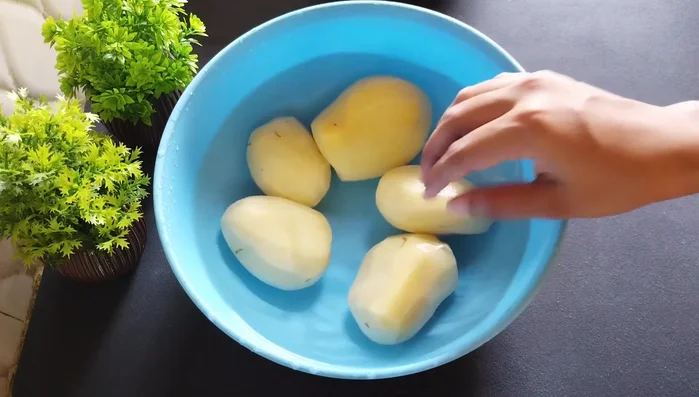 Peel and grate the potatoes using a grater with thick holes. Soak the grated potatoes in water to prevent browning.