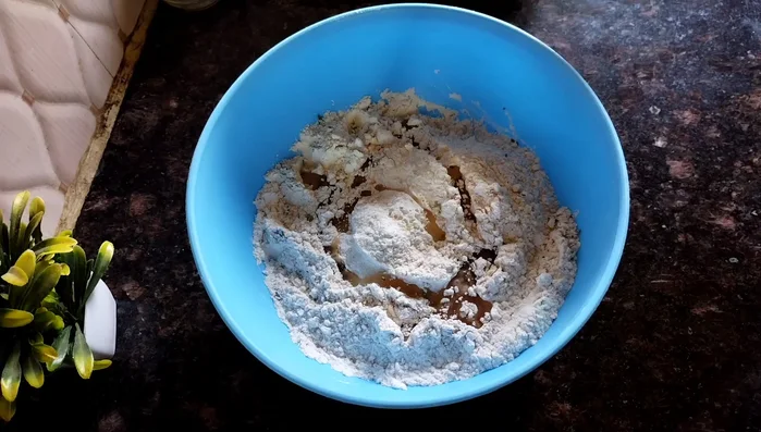 Add oil (or ghee) and mix thoroughly until a crumbly dough forms.