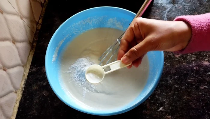 Add 1 teaspoon baking powder and 1/2 teaspoon baking soda (or 1 teaspoon Eno). Mix gently in one direction.