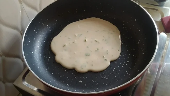 Cook the batter until lightly set, then flip it over.