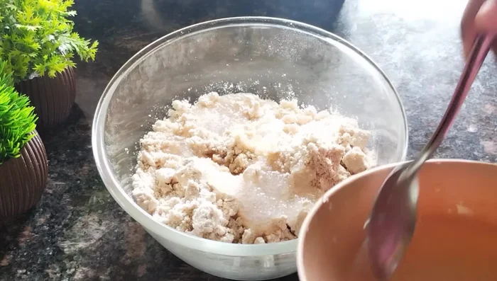 Gradually add the sugar-water mixture to the dry flour mixture, combining it gently until a dough forms. Do not overmix or knead; simply bring the ingredients together.