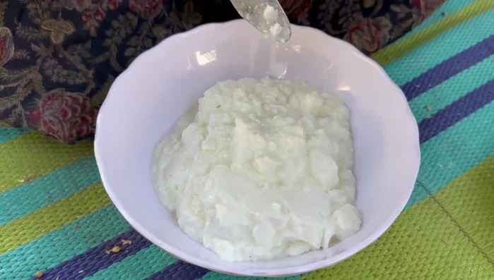 In a bowl, mix curd, gram flour, ginger-garlic paste, coriander, chopped chilies, turmeric powder, salt, and a little water. Beat well for 2 minutes.