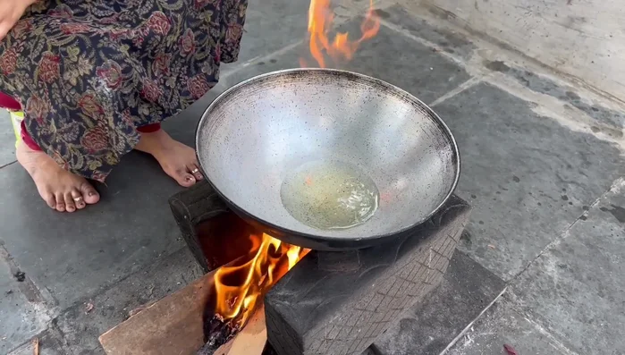 Heat oil in a kadhai. Add mustard seeds, cumin seeds, curry leaves, cloves, ginger-garlic paste (reserve half), and asafoetida.