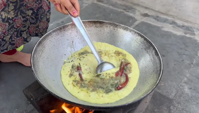 Add the curd mixture to the kadhai. Simmer, adding water to adjust consistency as needed.