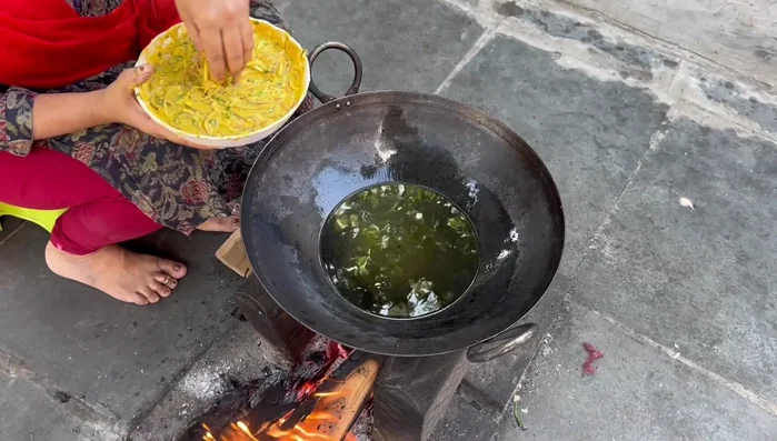 Heat oil in a pan. Fry pakoda batter in spoonfuls until golden brown.