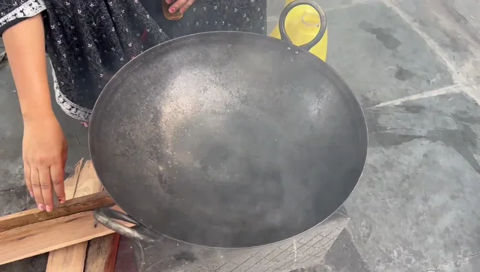 Heat oil in a kadai (wok).