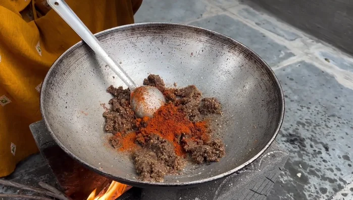 Add spices: red chili powder, homemade black masala, coriander powder, and turmeric powder. Add a little water and cook.