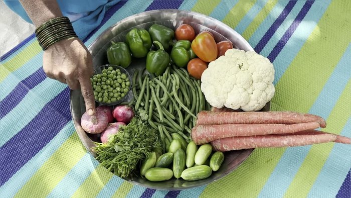 Peel and cut all vegetables (capsicum, tomato, cauliflower, carrot, coriander, onion, peas) into small pieces.