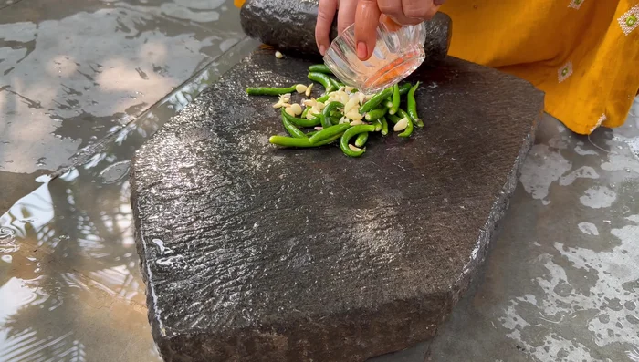 Chop green chilies, garlic, and cumin seeds finely.