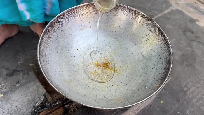 Heat a pan with oil. Add tejpaan (mustard seeds), then sauté finely chopped onions until color changes.