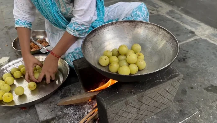 Add the steamed amla and finely chopped jaggery to a pan.