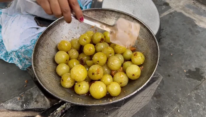 Cook the mixture, covered, for 10-15 minutes, checking periodically until the jaggery turns into a sugar paste and the amla begins to dry.