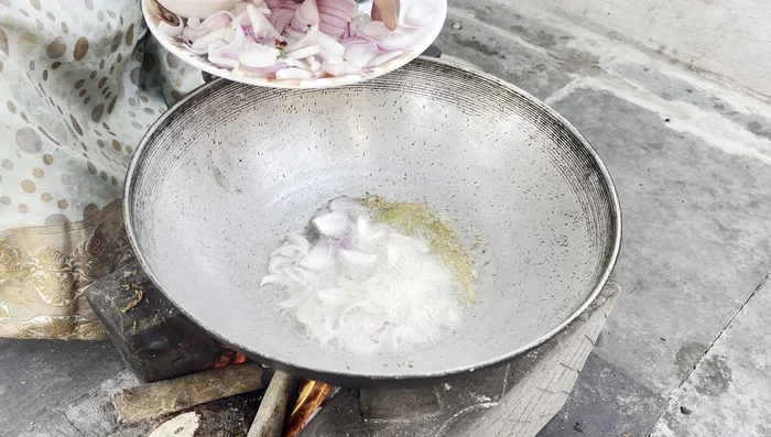 Add the sliced onions and green chilies. Fry until the onions are golden brown.