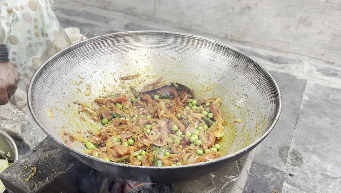Add the cooked cabbage and potatoes to the kadai with the fried spices. Add the water from the cooker.