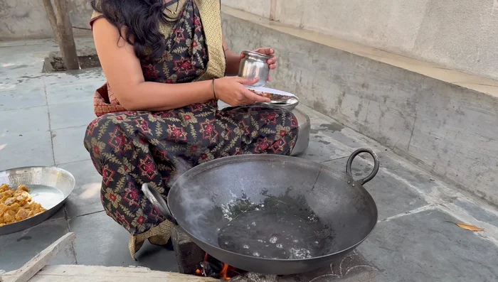 Boil jaggery in water in a copper pot until a thick, stiff paste is formed. It should make a sound when dropped.