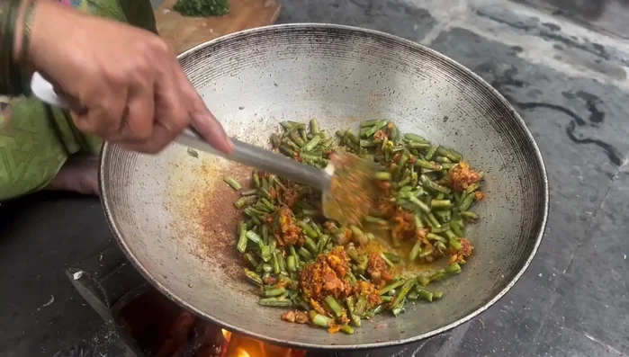 Add the steamed gawar, salt, and a little hot water to create a gravy. Cook until vegetables are tender.