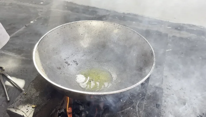 In a separate pan, heat ghee and sauté spices (cloves, chilies, green cardamom, ginger, green chilies).