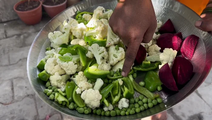 Add the coriander and capsicum. Add a spoon of beet bhaji for color and flavor.