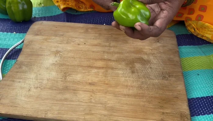 Finely chop the coriander leaves, green peas, and capsicum.