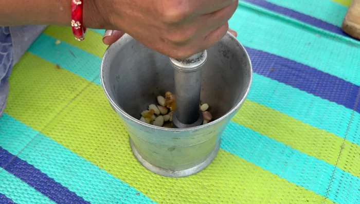 Grind the coriander leaves to a fine paste using a mortar and pestle.